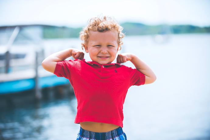 Kann Kalium Ihre Knochengesundheit verbessern? A child showing his muscles with the help of potassium