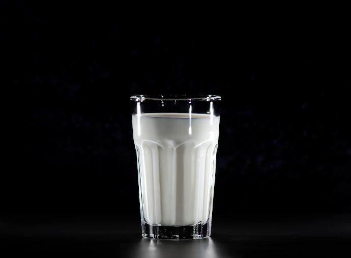 Kann Kalium Ihre Knochengesundheit verbessern? A glass of milk in black background