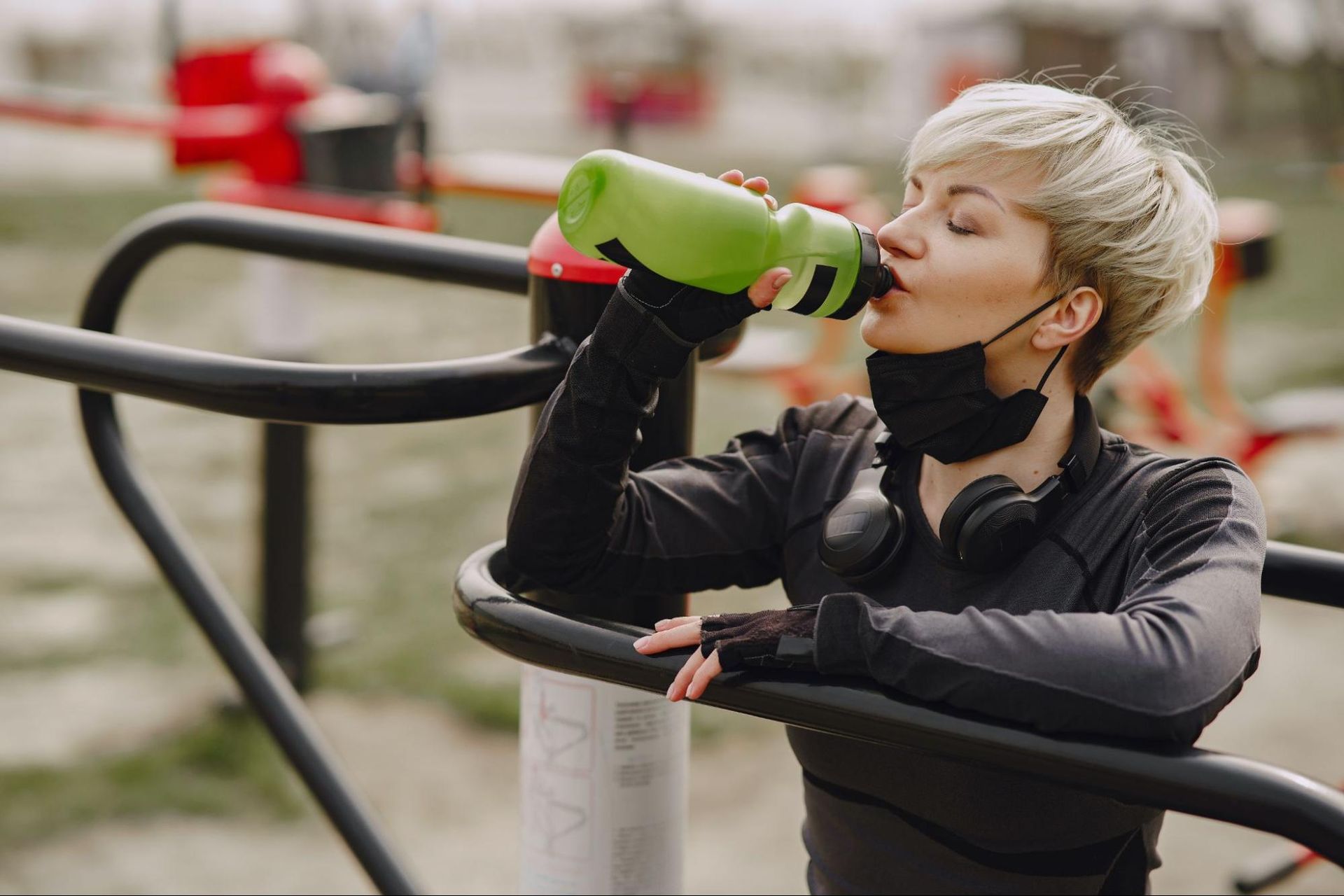 A girl drinking water for hydration while in a park