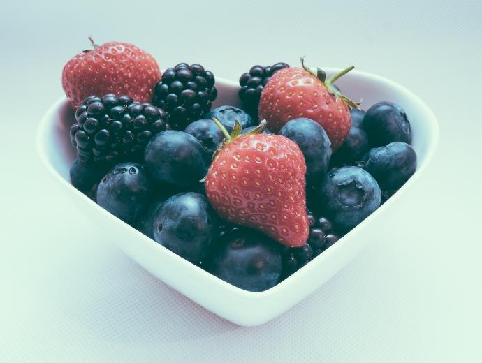 A heart shaped bowl full of berries
