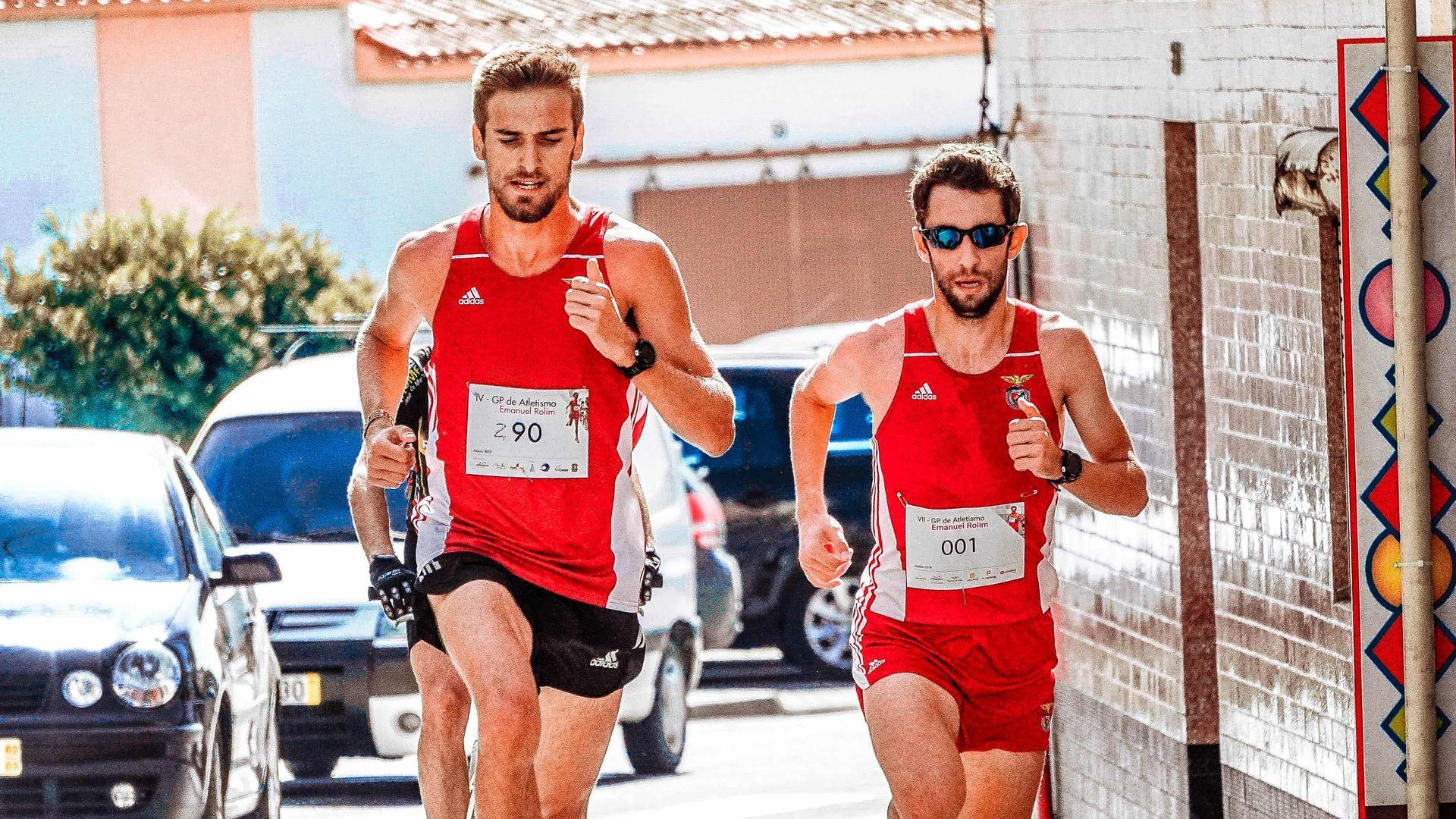 Two male runners doing a marathon in red singlet